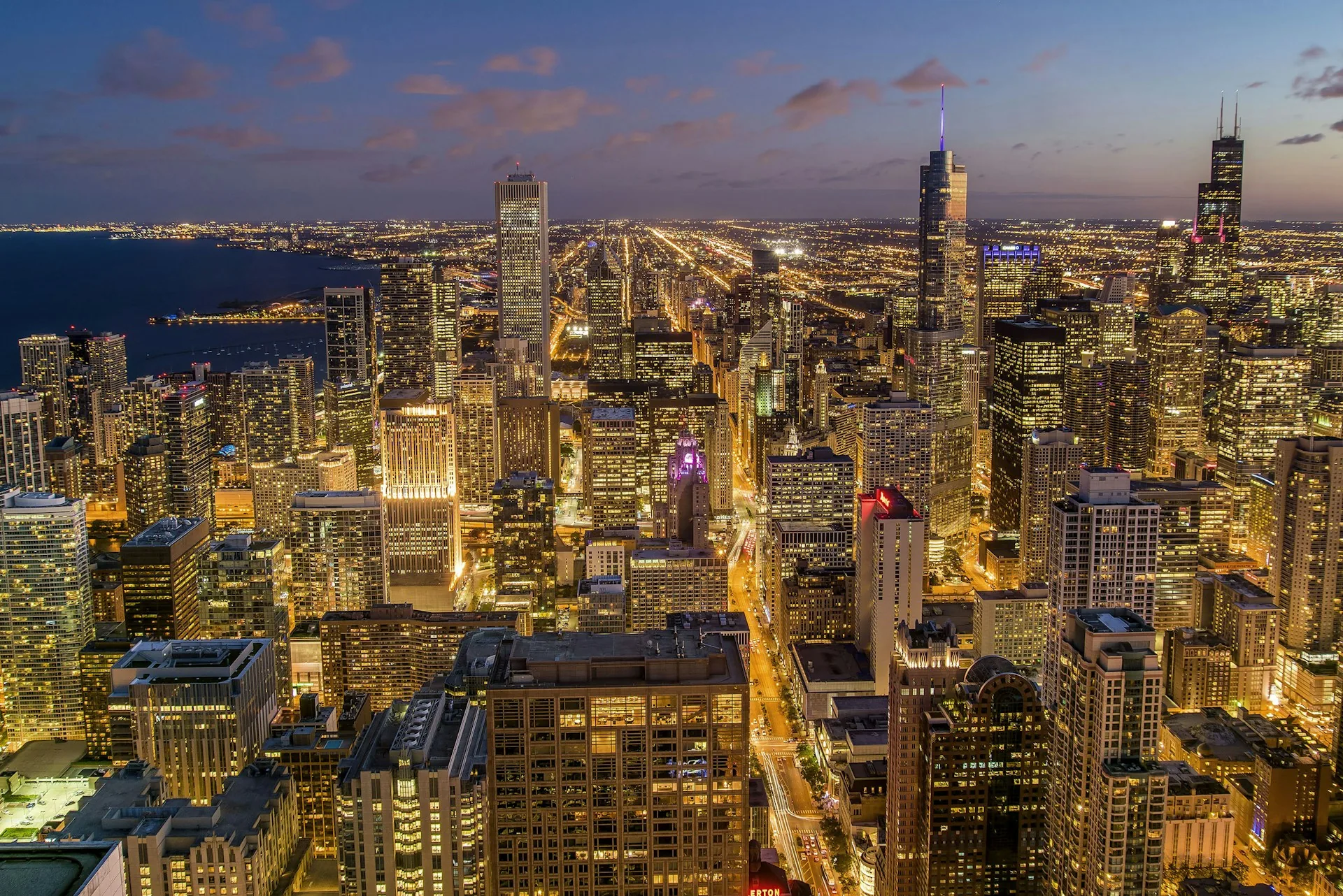 Chicago skyline glowing at dusk beside Lake Michigan